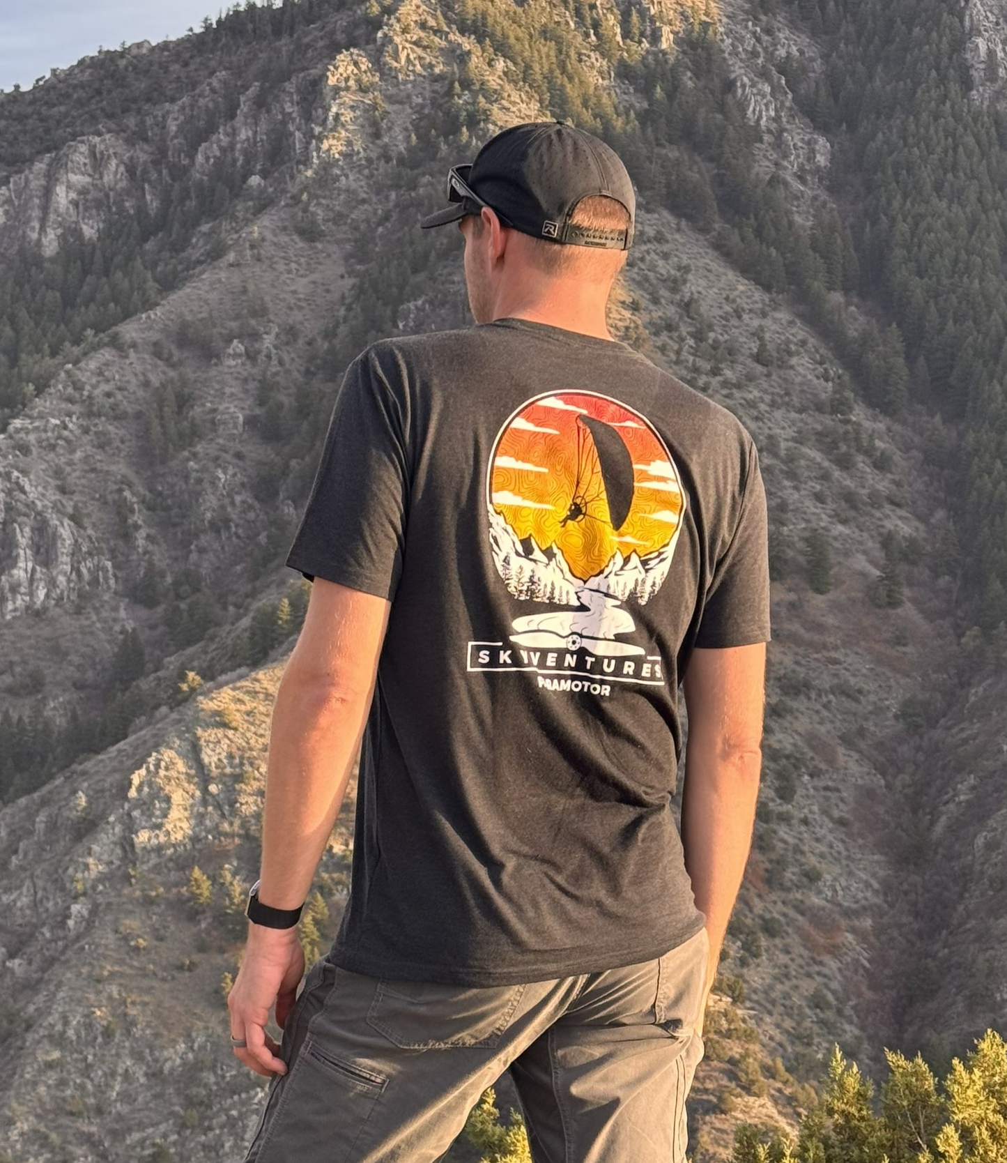 Person wearing a t-shirt with a mountain design in a natural setting