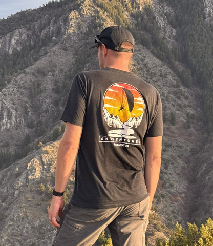 Person wearing a t-shirt with a mountain design in a natural setting